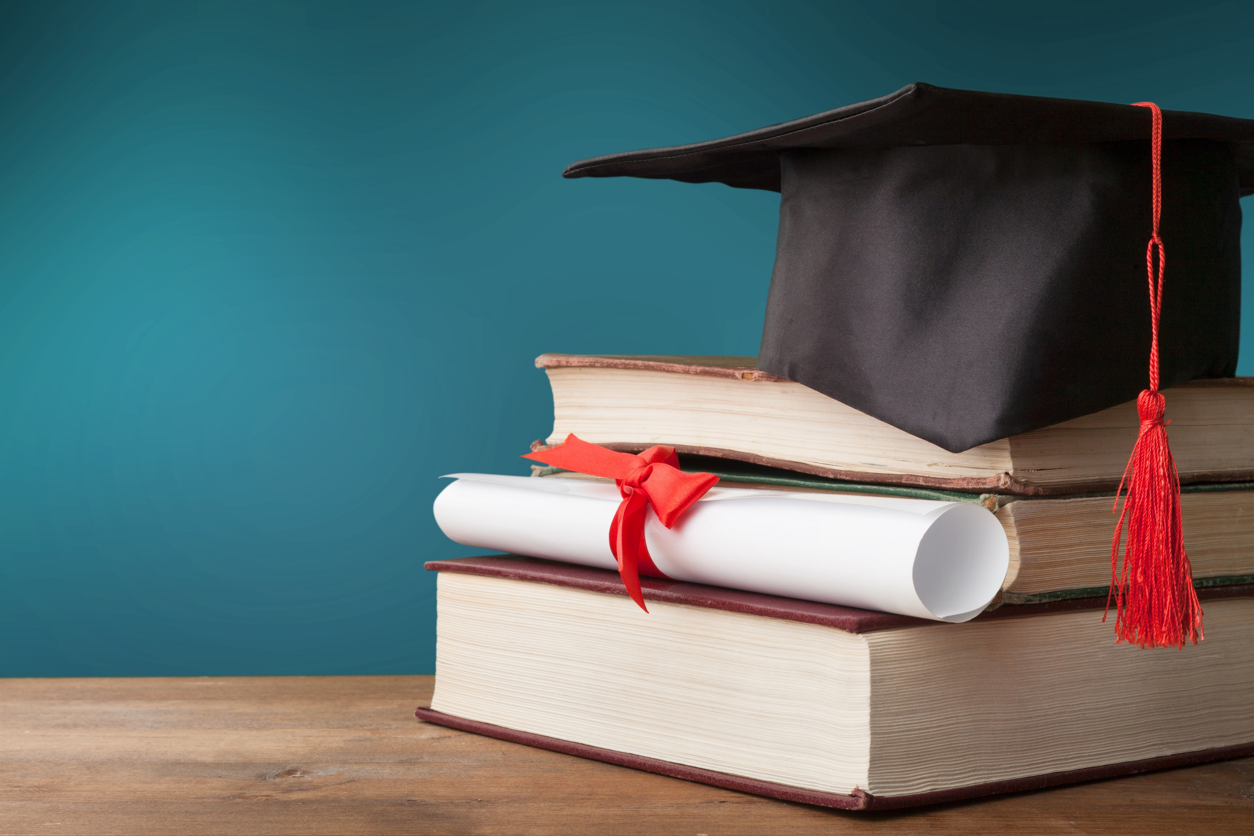 Graduation hat, stack of books, and degree