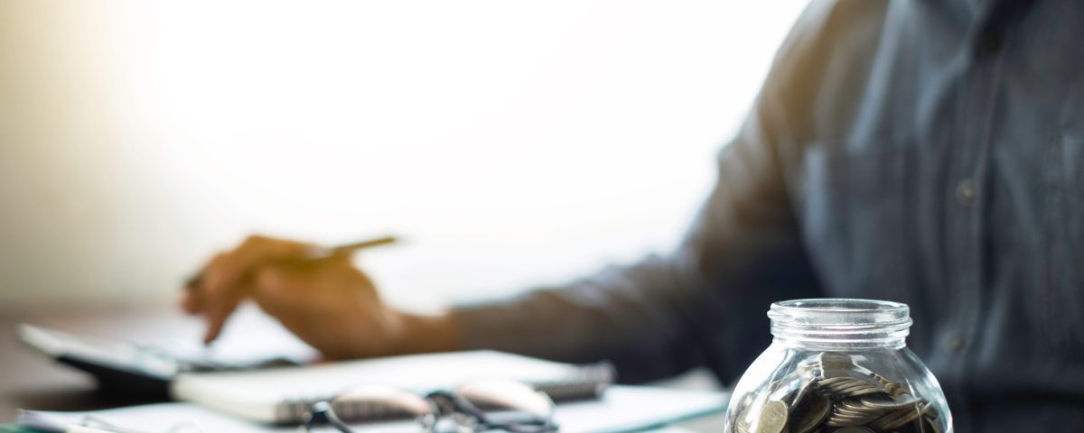 Person organizing finances with coins laid out in front of them