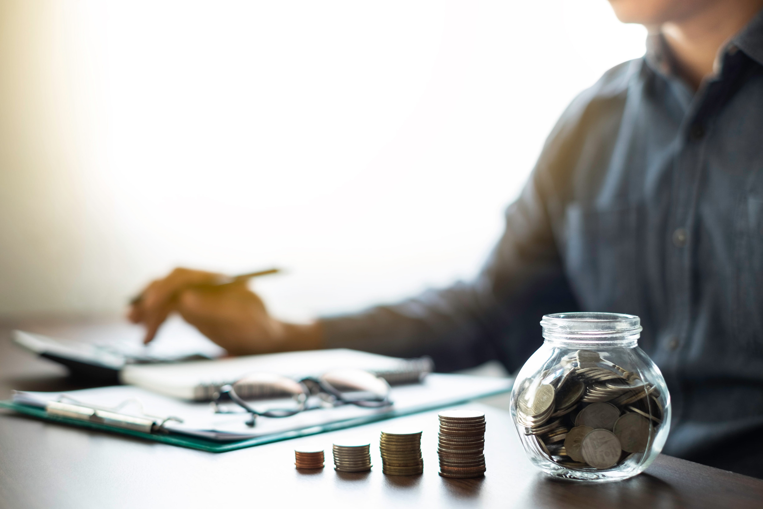 Person organizing finances with coins laid out in front of them